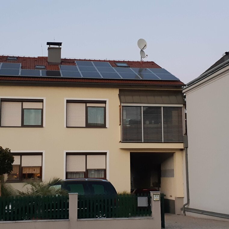 Photovoltaikanlage auf einem gelben Haus mit Schrägdach