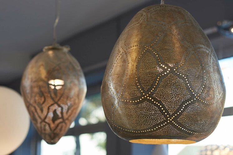 Zwei goldene, tropfenförmige Lampenschirme mit unterschiedlichen Mustern